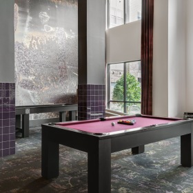 Everything within reach a room with large windows and a pool table