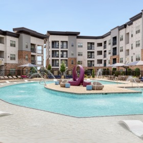 Resort-style swimming pool swimming pool with lounge chairs in a courtyard
